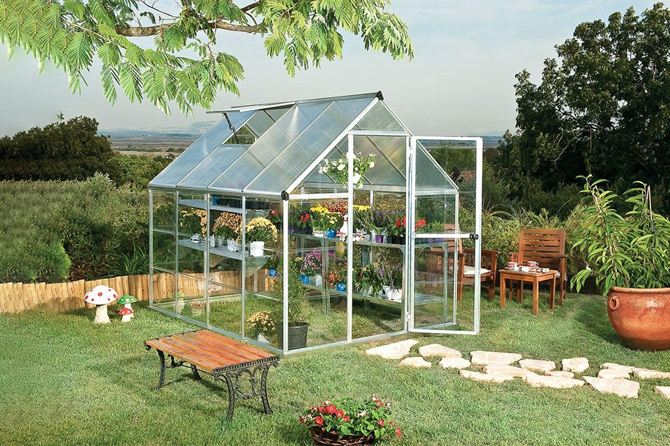 A glass greenhouse in a garden.